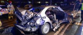 Na zdjęciu rozbity samochód osobowym z lewej strony stoi ratownik PSP