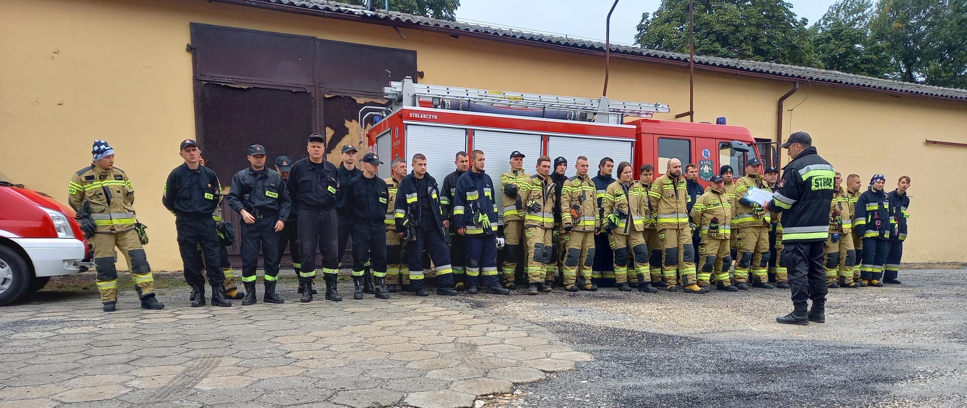 Strażacy stoją na zbiórce przed ćwiczeniami.