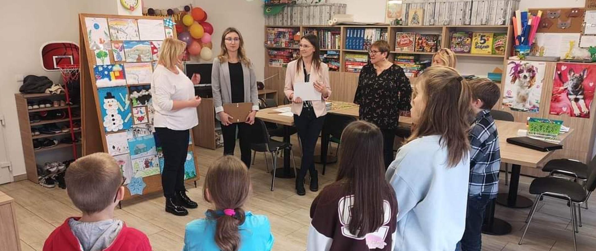 Zdjęcie przedstawia pracowników PSSE w Kamieniu Pomorskim i przedstawicielki KGW "Fregata" w Międzywodziu wręczających dyplomy dzieciom, które brały udział w konkursie