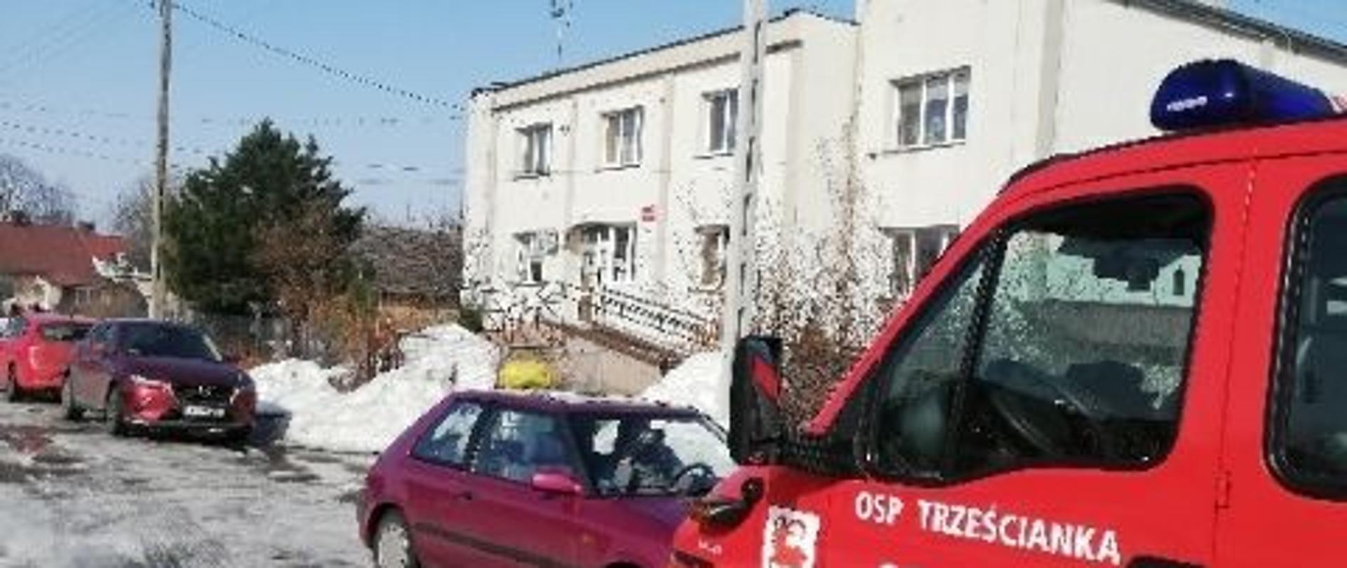 Na tle ośrodka zdrowia w Narwi czerwony strażacki samochód z napisem OSP Trześcianka