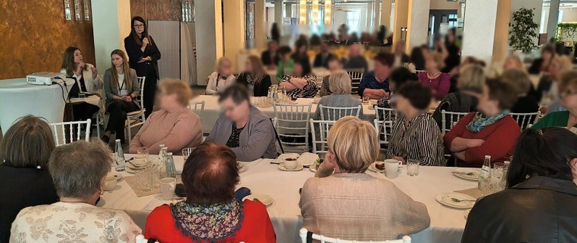 Licznie zgromadzeni uczestnicy siedzą w sali. Przed nimi są przedstawiciele US w Strzyżowie