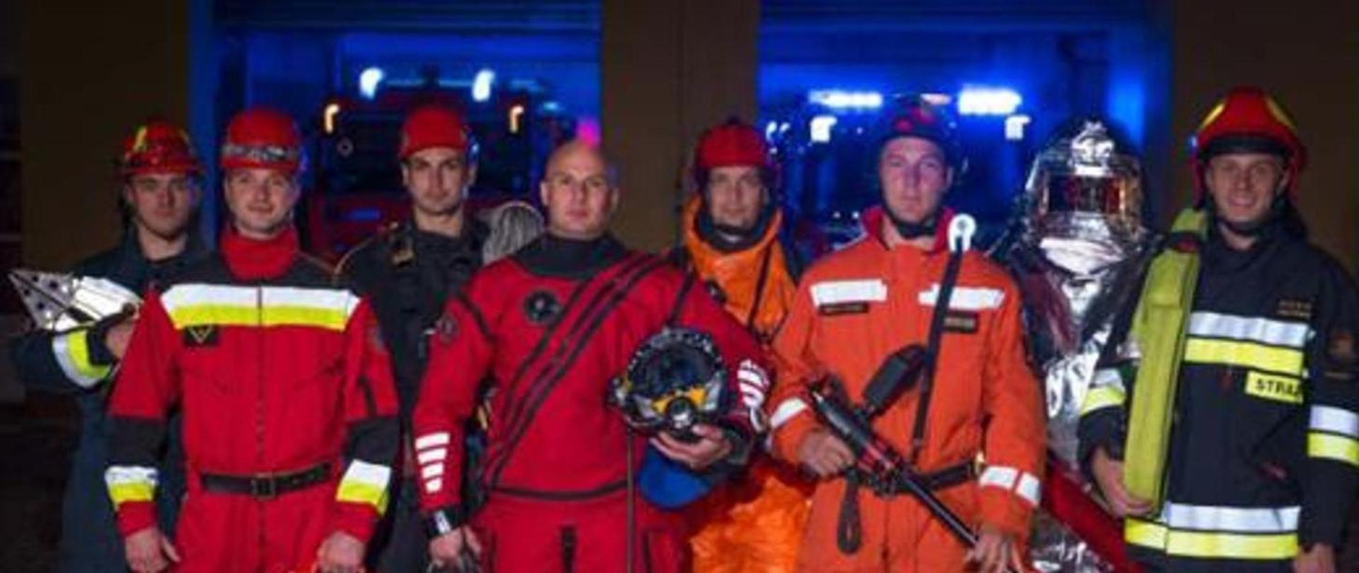 Zdjęcie przedstawia strażaków ubranych w różnego rodzaju ubrania ochronne