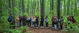 Grupa młodzieży szkolnej w lesie w trakcie warsztatów