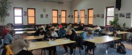 Eliminacje Powiatowe Ogólnopolskiego Turnieju Wiedzy Pożarniczej 2024 - w sali uczniowie piszą test wiedzy