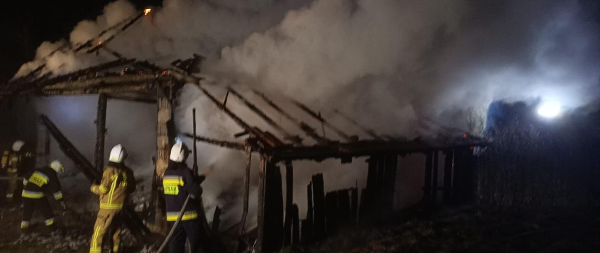 Strażacy gaszą płonący budynek