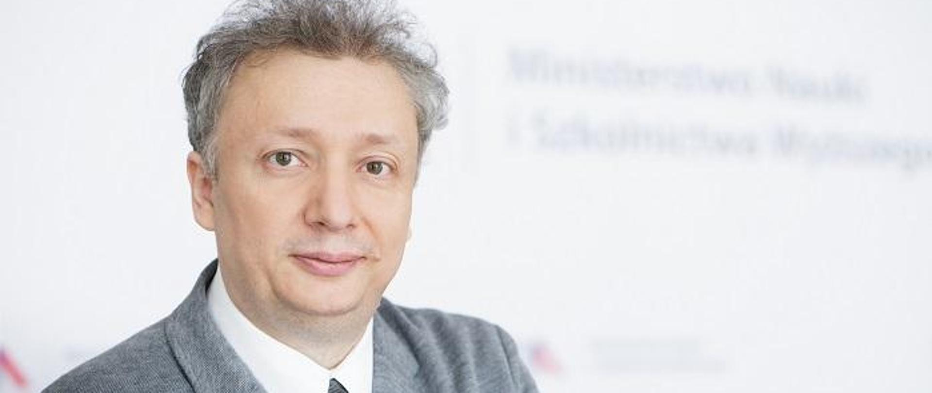 Minister Skuza na tle ściany