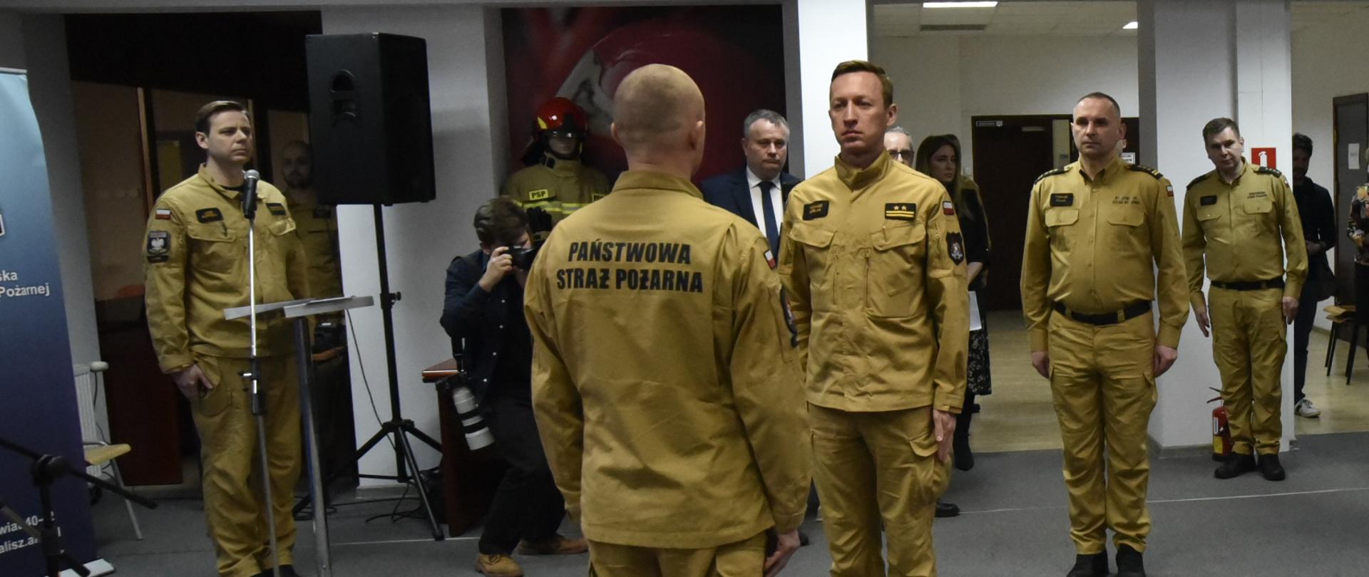 składani meldunku strażakowi przez innego strażaka, z boku stoi duża grupa ludzi