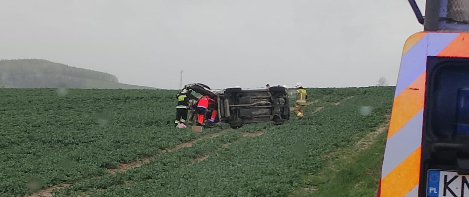 Samochód osobowy na boku na polu ornym