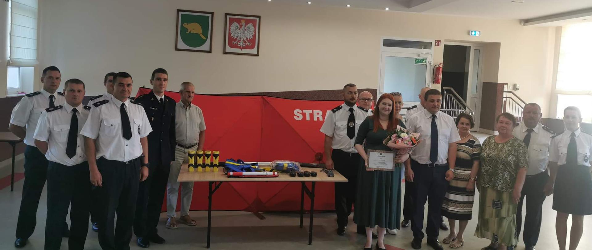 Zdjęcie przedstawia moment uroczystego przekazania sprzętu pozyskanego dla OSP w Bobrowie. Obok sprzętu przedstawiciele OSP oraz zaproszeni goście.