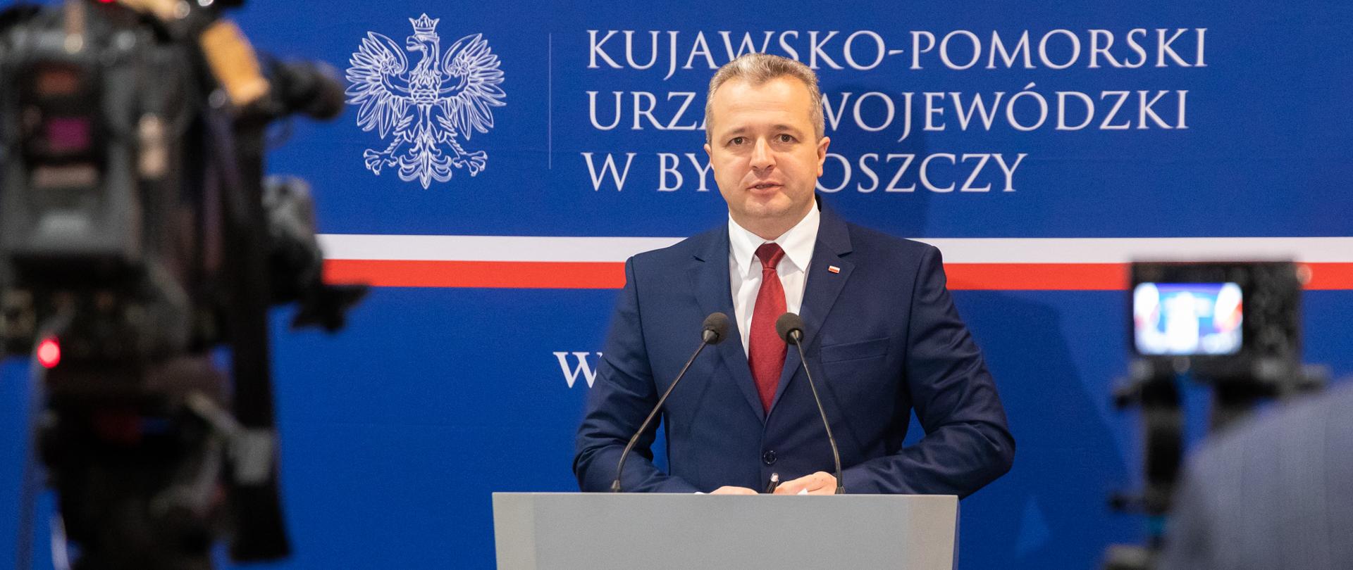 Jeden mężczyzna stojący przy mównicy i wypowiadający się