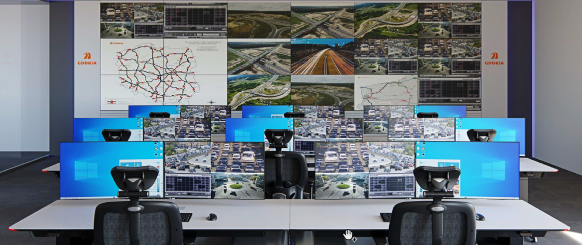  W budynku przy ul. Płaskowickiej w Warszawie będzie funkcjonować Krajowe Centrum Zarządzania Ruchem. Na zdjęciu widać biurka operatorów z ustawionymi ekranami monitorów, a na ścianie przed nimi duży ekran z podziałem na mniejsze okienka umożliwiający monitoring wielu odcinków dróg.