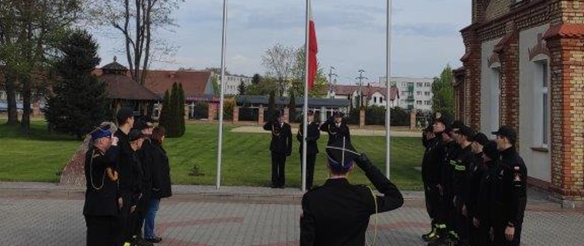 Strażacy na uroczystej zbiórce oddają honor fladze Państwowej