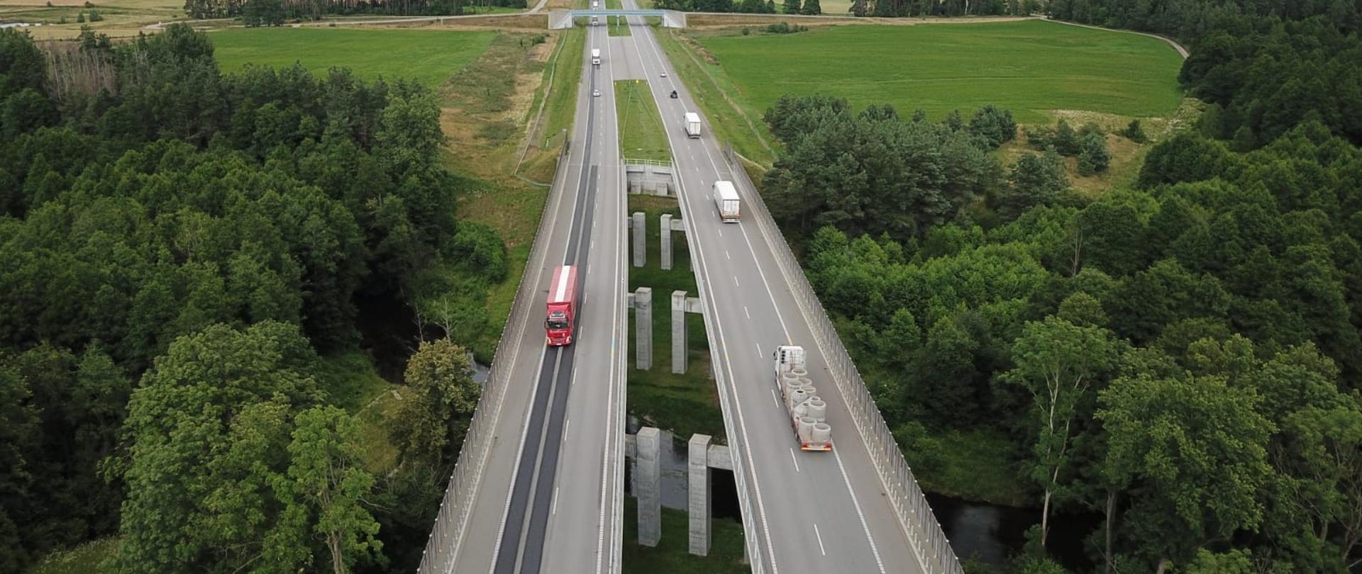 Widok z góry na 2 jezdnie obok siebie, każda z mostem nad rzeczką. Po bokach las, 