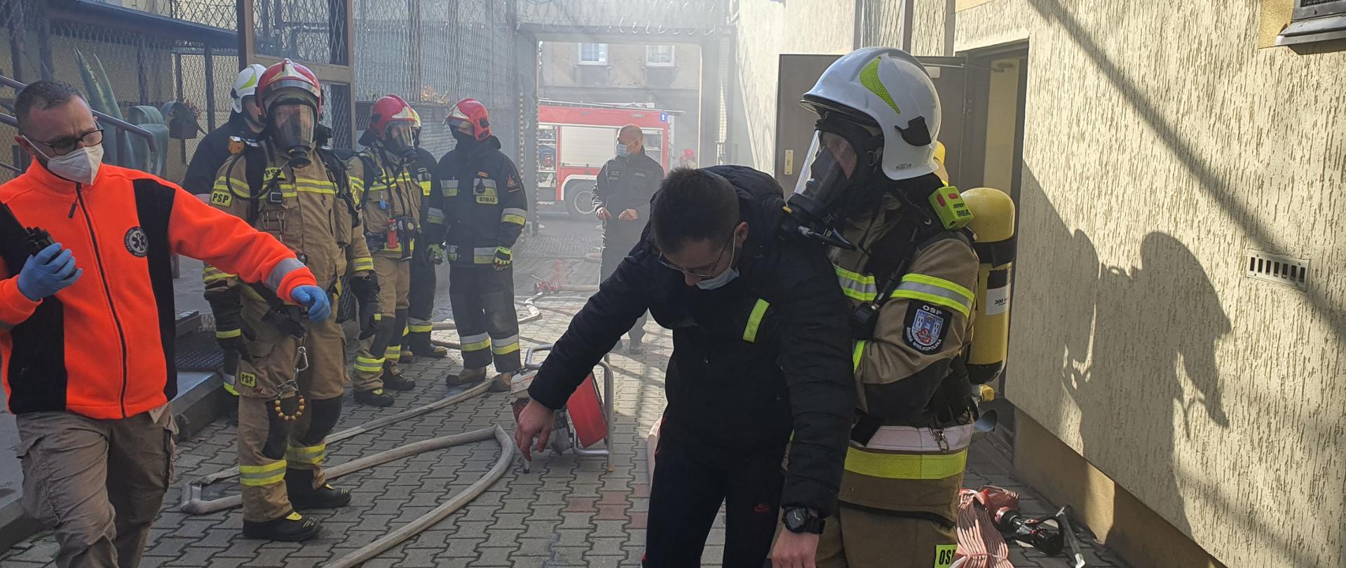 Na zdjęciu strażacy ewakuują osobę poszkodowaną podczas ćwiczeń w zakładzie karnym