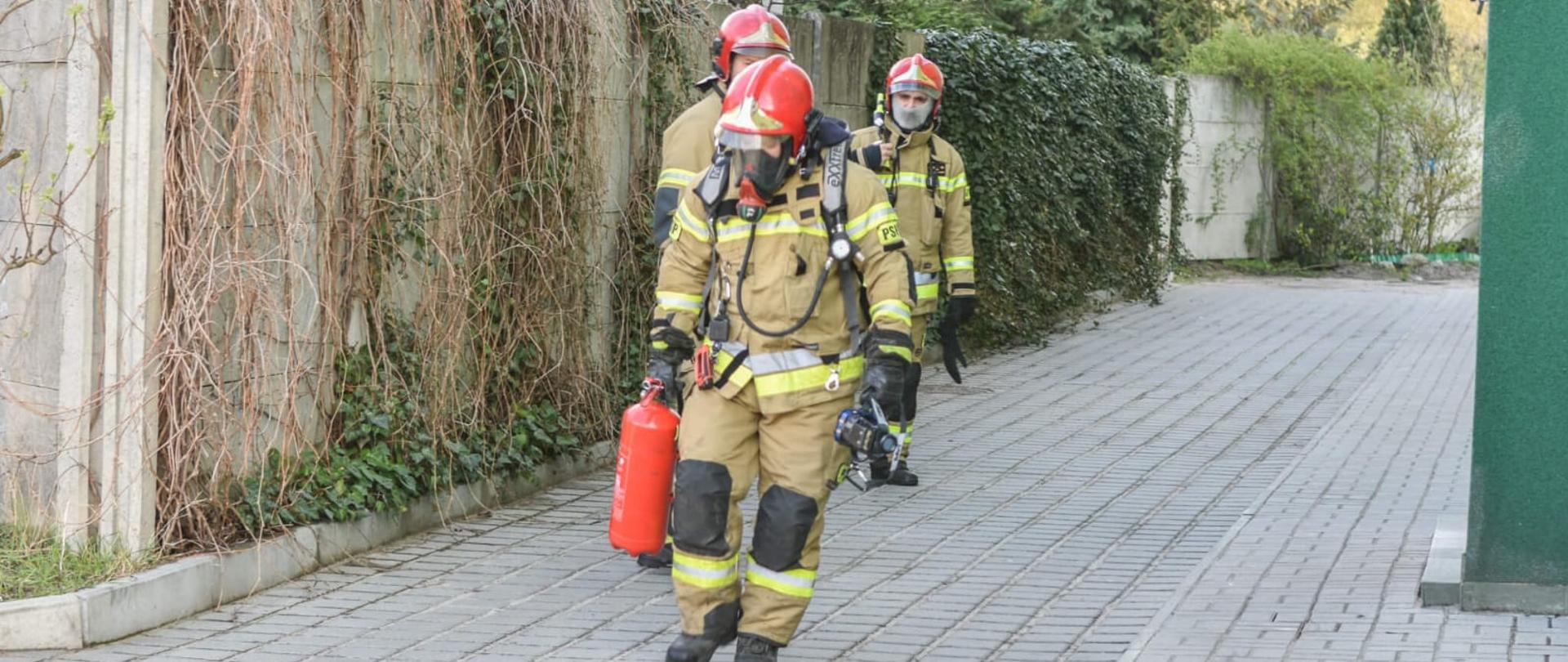 Pożar mieszkania z trojgiem dzieci w środku - strażacy wychodzący z budynku