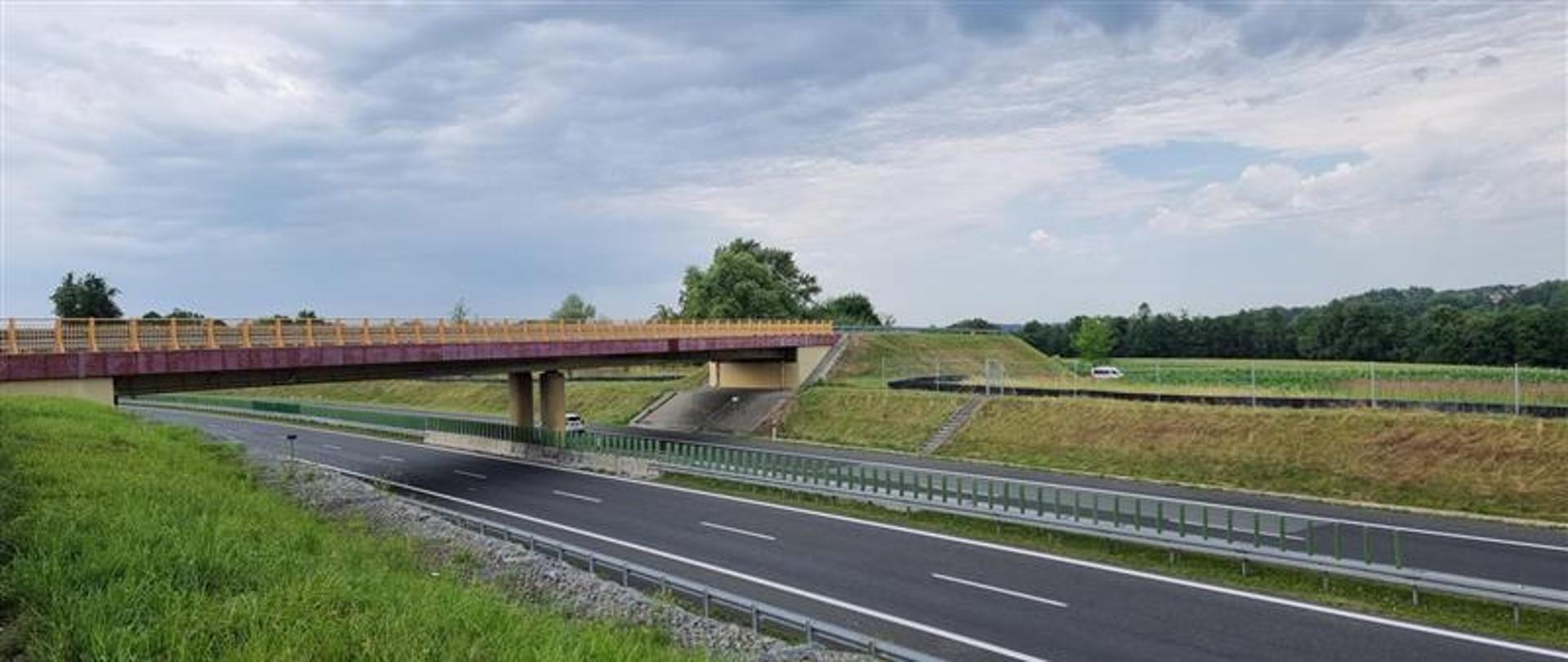 Na fotografii można zauważyć pustą drogę ekspresową S52 w okolicy Grodźca. Nawierzchnia jest bitumiczna, nad S52 znajduje się wiadukt w ciągu drogi powiatowej