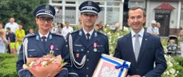 2 policjantów w mundurach oraz mężczyzna w garniturze, wicewojewoda, pozują do zdjęcia