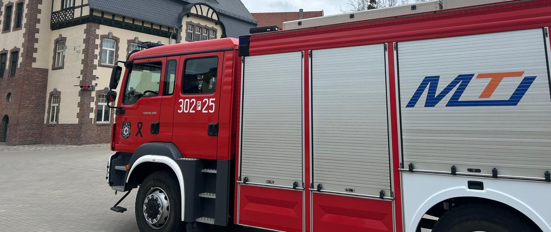 Ciężki samochód gaśniczy na tle budynku jednostki JRG nr 2
