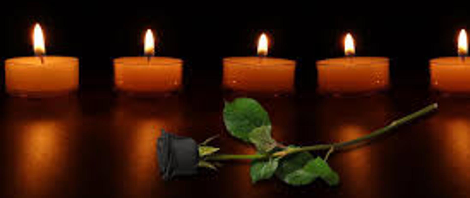 Na ciemnym tle pięć świec i czarna róża.