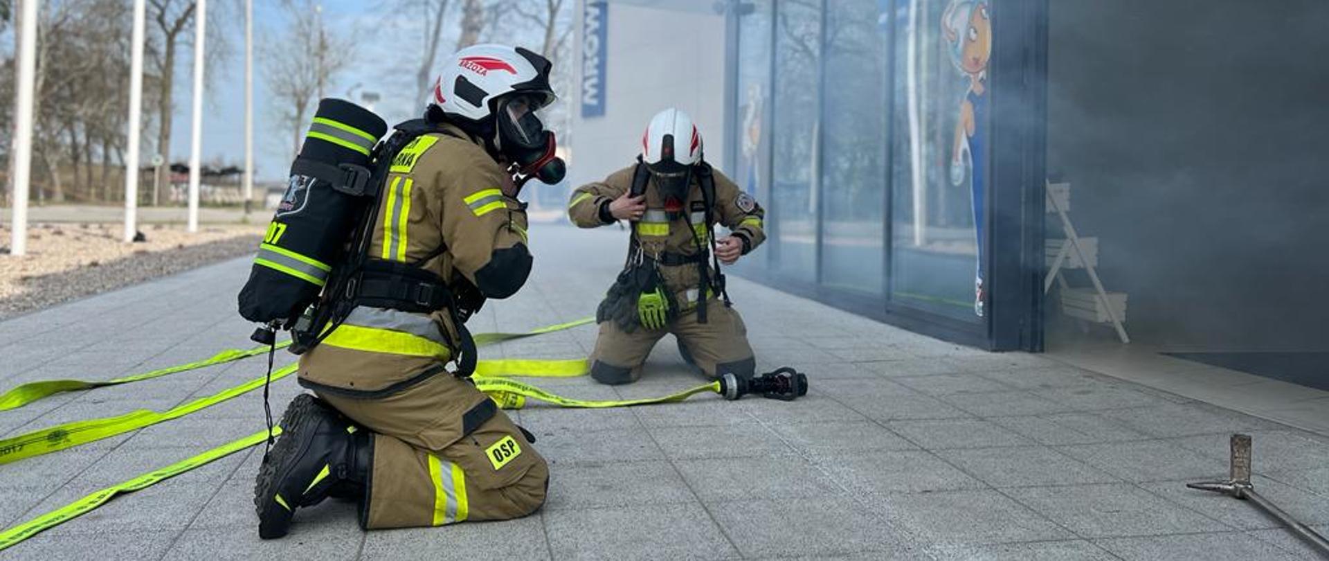 Strażacy przygotowują się do wejścia do budynku