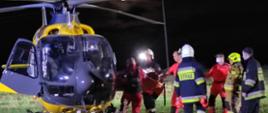 Zdjęcie przedstawia moment umieszczania poszkodowanego w śmigłowcu LPR przez służby ratownicze
