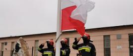Zdjęcie przedstawia kieleckich strażaków przed jednostką podczas uroczystej zmiany służby i podniesienia flagi na maszt.