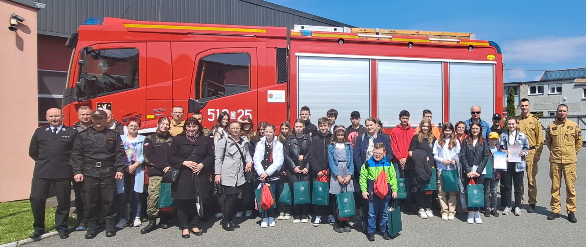 zdjęcie grupowe Uczestników Konkursu Wiedzy Pożarniczej na tle samochodu pożarniczego. 