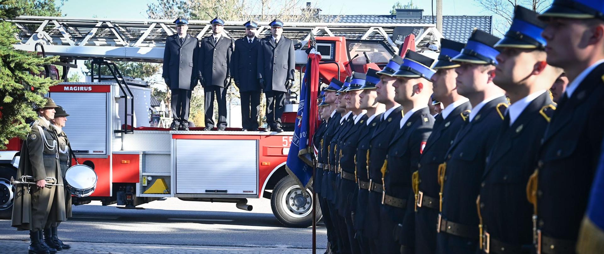 Strażacy stoją w pododdziale przed kościołem, będąc przygotowanym na przejście trumny z ciałem zmarłego strażaka. 