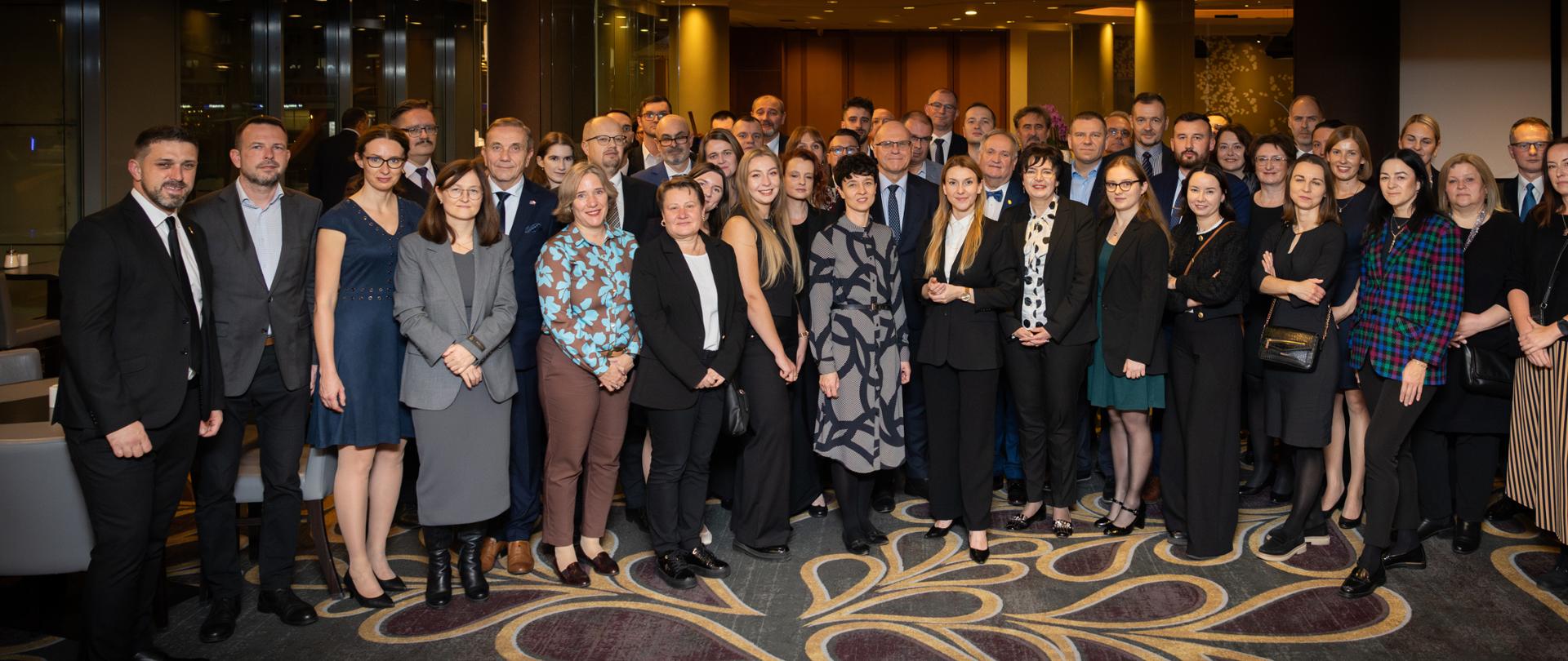 Duża grupa ludzi elegancko ubrana pozuje to zdjęcia 