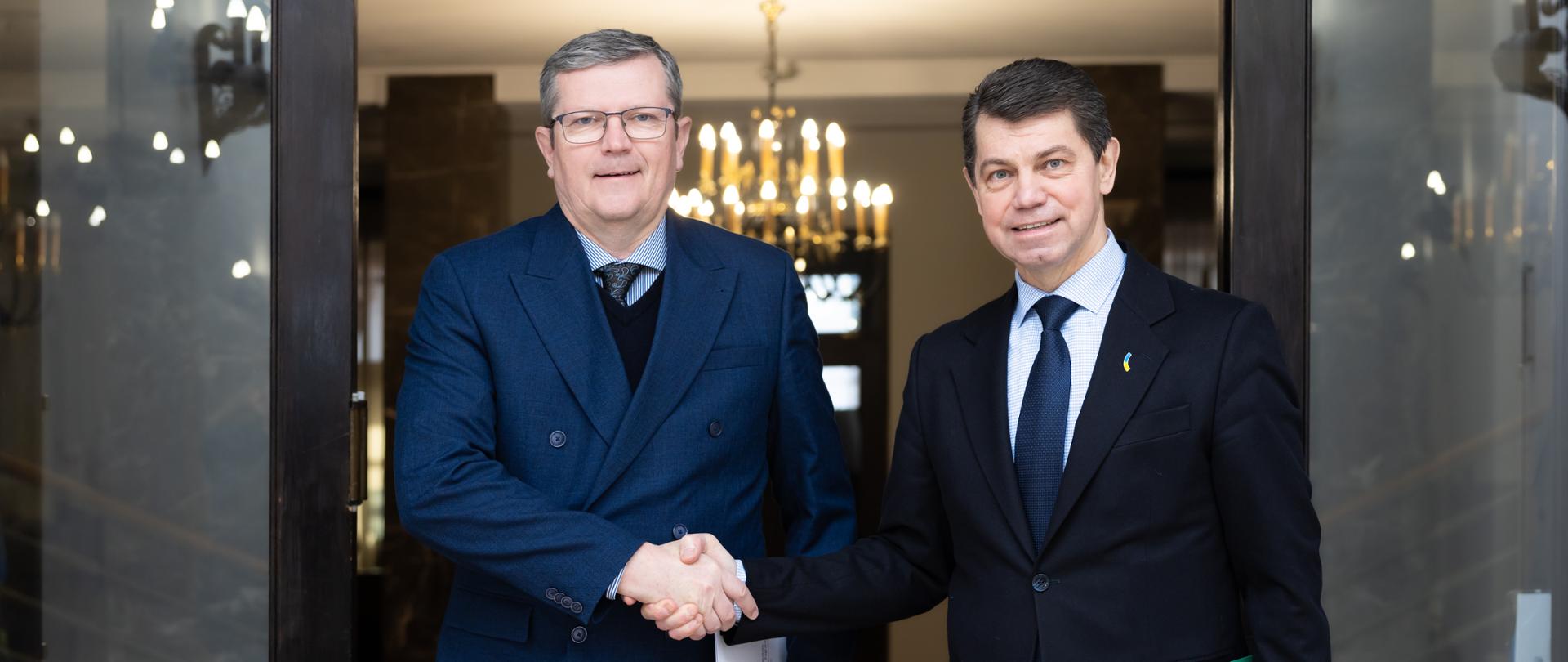 Dwóch wiceministrów podczas uścisku dłoni.