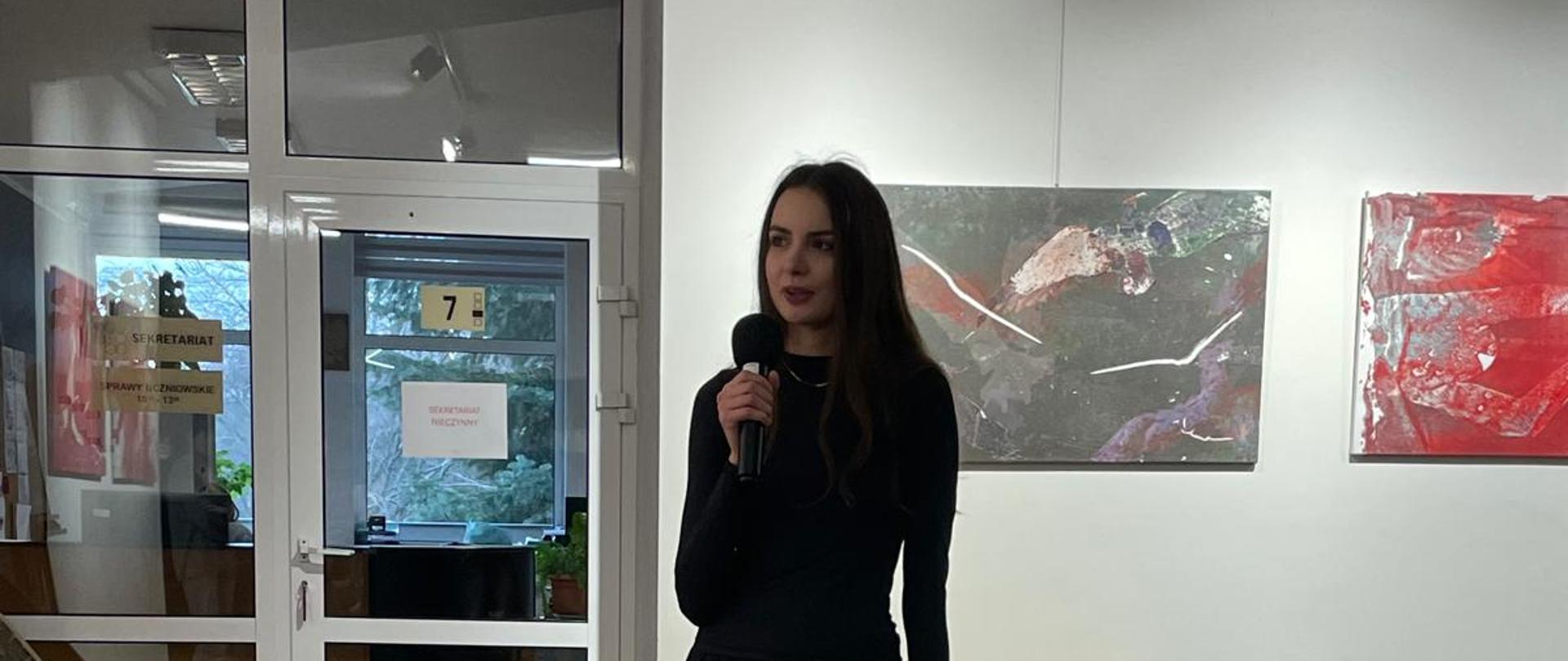 Fotografia ukazująca artystkę - Dorotę Bujak na tle Jej prac