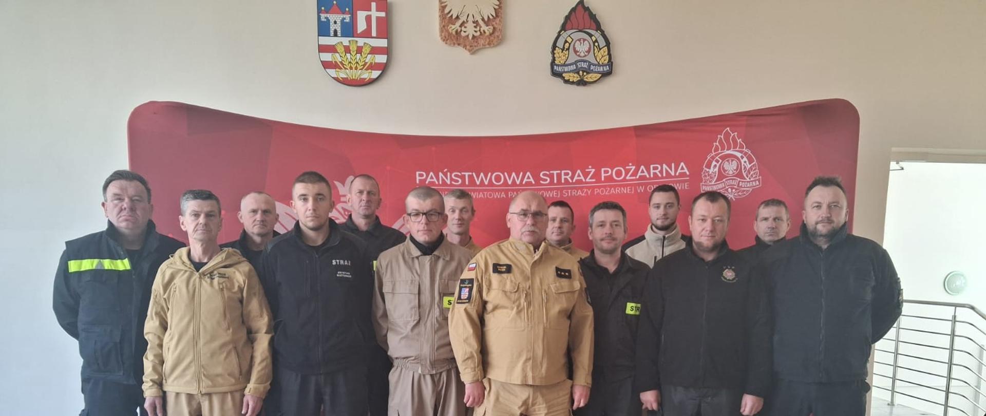 Strażacy stojący w umundurowaniu koszarowym oraz służbowym