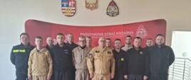 Strażacy stojący w umundurowaniu koszarowym oraz służbowym