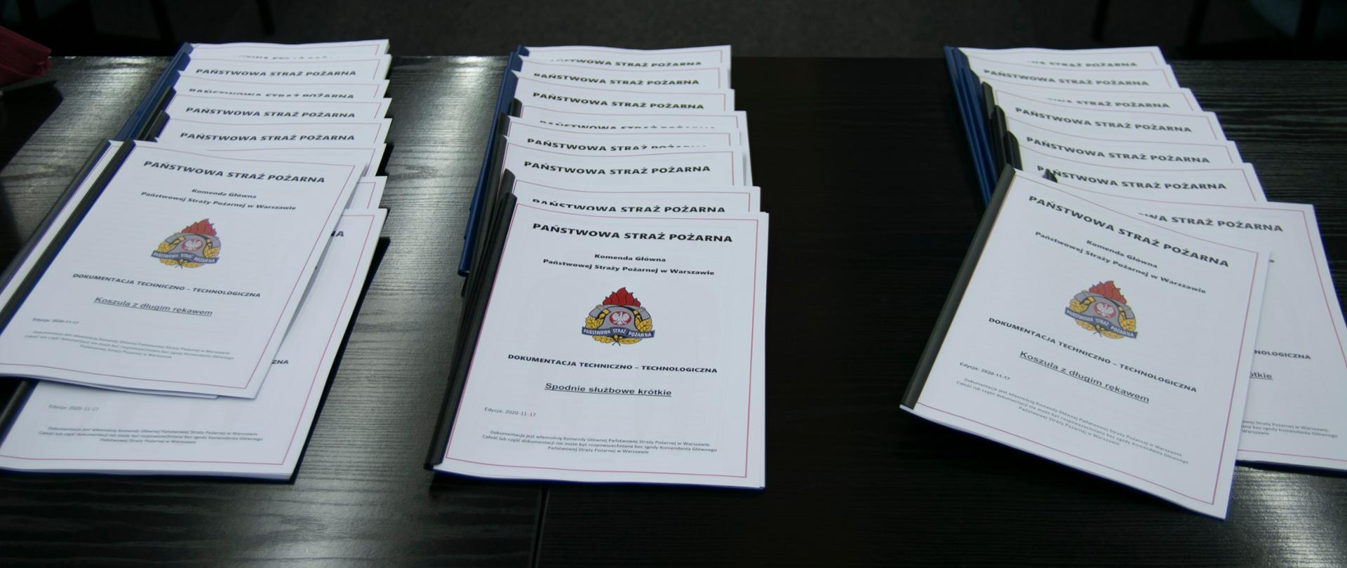 Leżące na stole skrypty będące dokumentacją techniczno-technologiczną nowego umundurowania