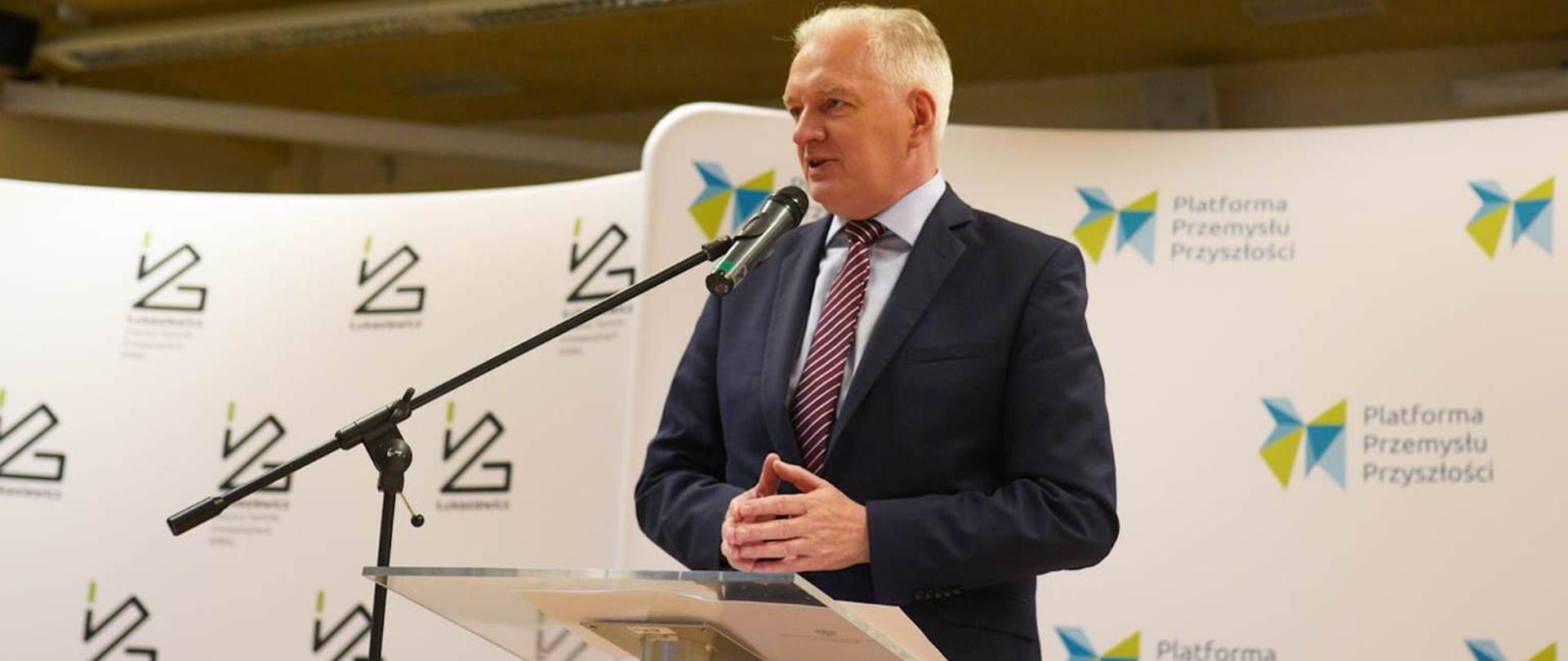 Wicepremier Jarosław Gowin stoi przed pulpitem i mówi do przedstawicieli świata nauki i biznesu ze Śląska.