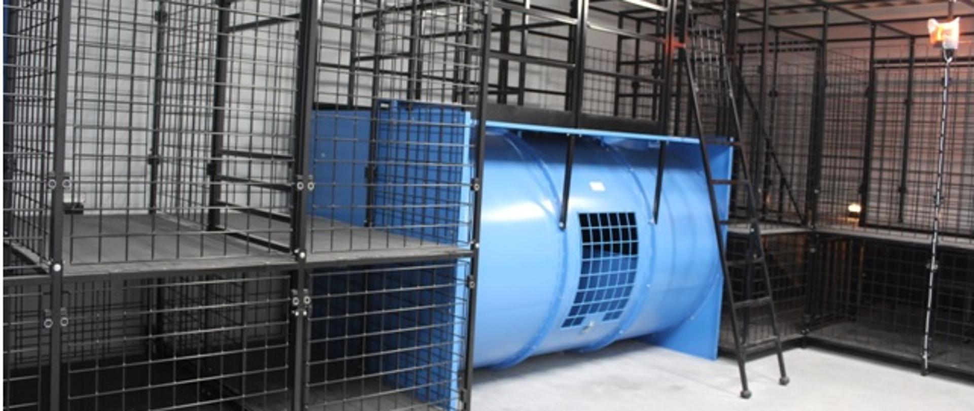 Zdjęcie przedstawia widok komory dymowej na Jednostce Ratowniczo-Gaśniczej Nr 3 w Rzeszowie. Komora dymowa ma formę stalowej, okratowanej konstrukcji ścieżki treningowej – labiryntu z różnego rodzaju otworami, poziomami i przejściami.