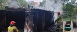 
Fotografia przedstawia działania strażaków podczas pożaru garażu.