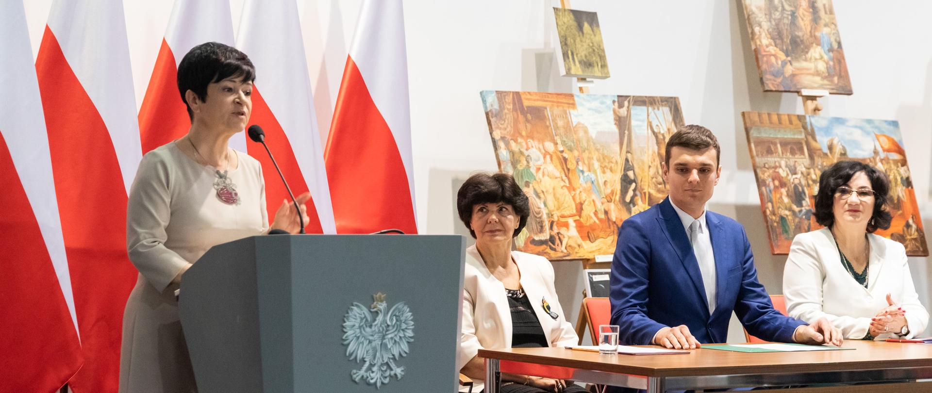 
Grupa ludzi w sali z obrazami
