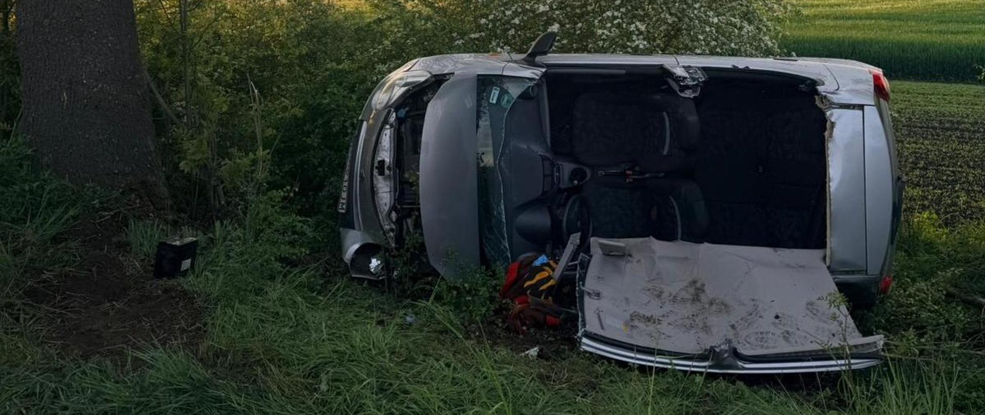 Uszkodzony samochód na boku w rowie, wycięty dach