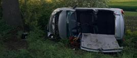 Uszkodzony samochód na boku w rowie, wycięty dach