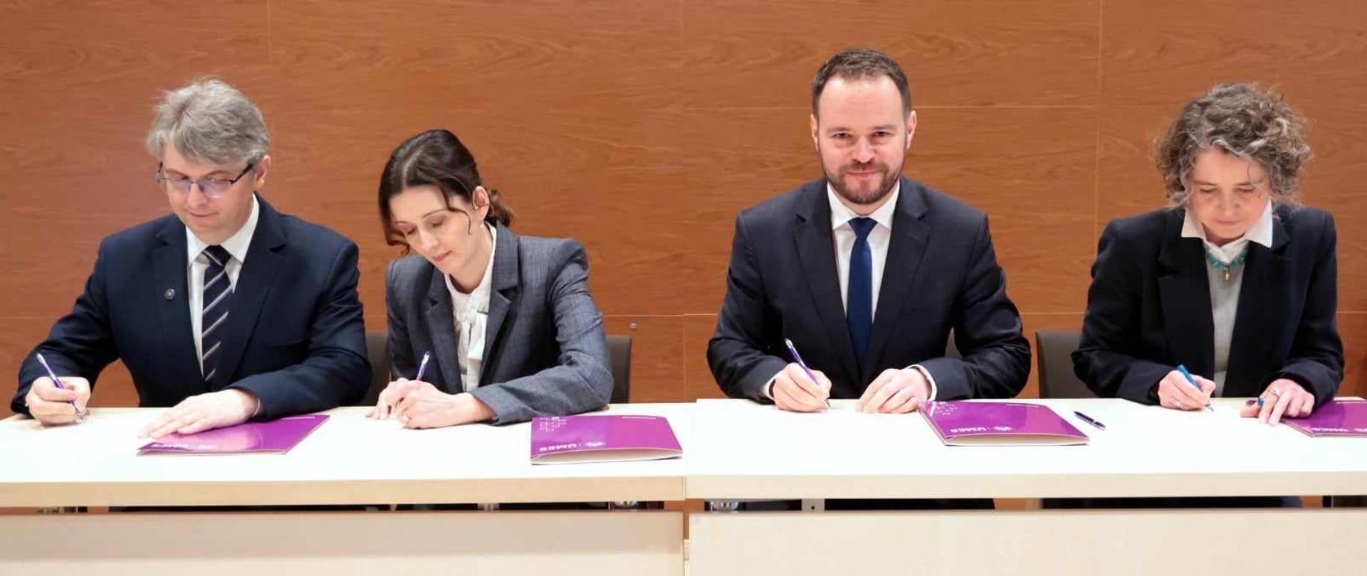 Cztery osoby podpisują deklarację. 