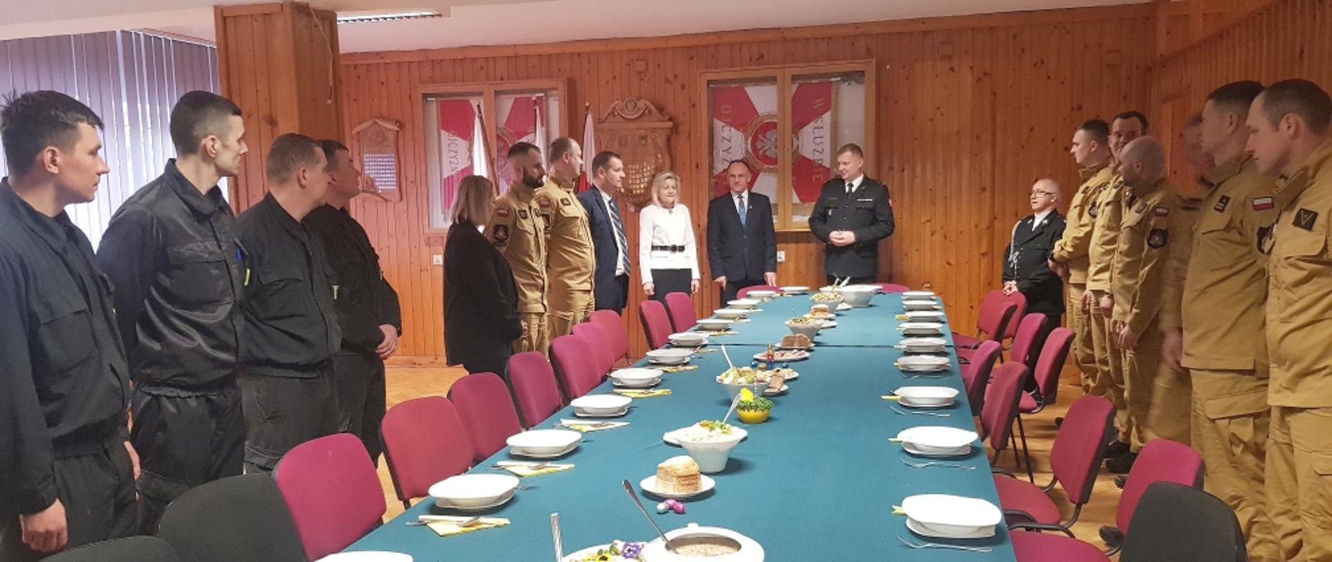 funkcjonariusze i zaproszeni goście zgromadzeni przy stole podczas spotkania wialkanocnego
