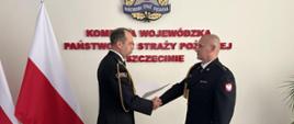 Na zdjęciu znajdują się: Zachodniopomorski Komendant Wojewódzki st. bryg. Mirosław Pender oraz powołany na stanowisko Zastępcy Komendanta Powiatowego PSP w Wałczu kpt. Grzegorz Brusiło. Strażacy ustawieni frontem do siebie. Kpt. Brusiło otrzymuje z rąk Komendanta Wojewódzkiego decyzję personalną.