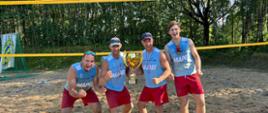 Dwie pary strażaków z Ełku na tle boiska do siatkówki plażowej
