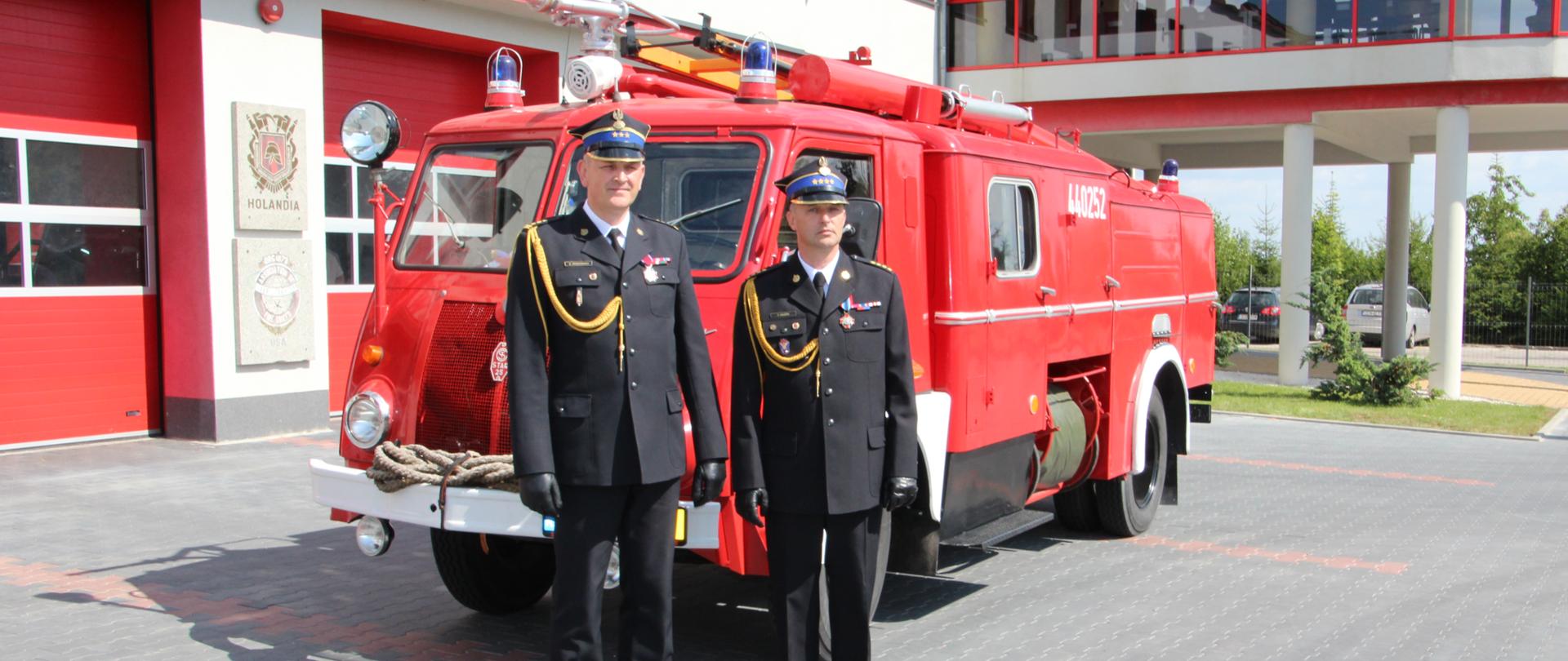 Na zdjęciu w umundurowaniu wyjściowym na tle zabytkowego samochodu ratowniczo-gaśniczego stoją Zastępca Kujawsko-Pomorskiego Komendanta Wojewódzkiego PSP wraz z nowo powołanym Komendantem Powiatowym PSP w Chełmnie. 