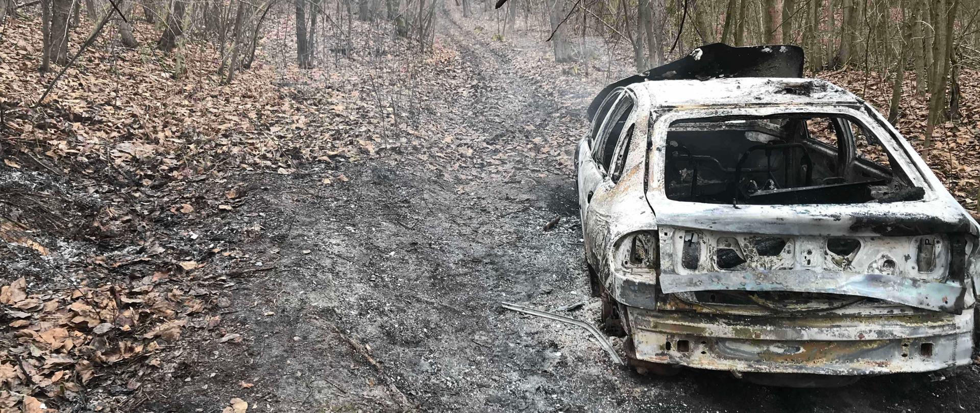 Pożar samochodu i ściółki w lesie w miejscowości Skrzypaczowice gmina Łoniów
Opis Alternatywny: Zdjęcie przedstawia samochód osobowy po ugaszeniu pożaru, samochód stoi w leśnej dróżce, obok widać wypaloną ściółkę leśną.
