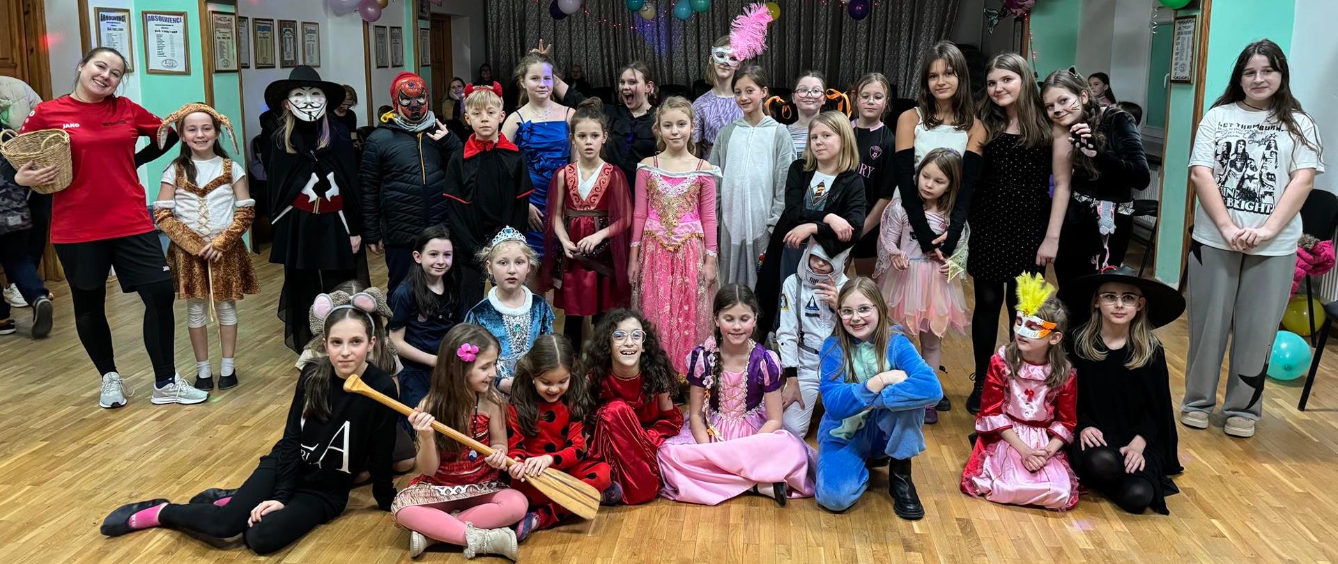 Zdjęcie przedstawiające uczestników zabawy karnawałowej, która odbyła się 12 lutego 2024 roku w auli szkoły.