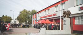 Strażacy i goście stoją przy pomniku.