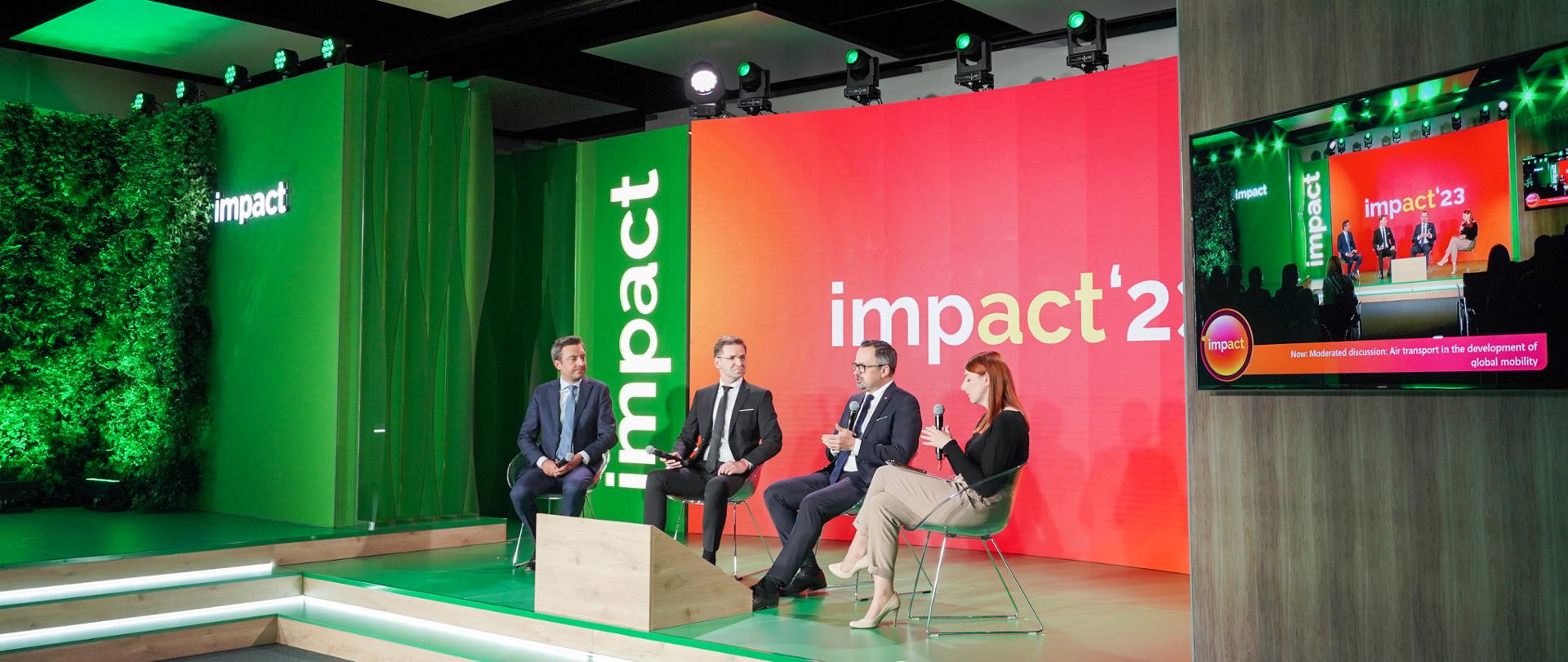 Cztery osoby siedzą obok siebie na scenie. Drugi z prawej siedzi wiceminister Marcin Horała. 