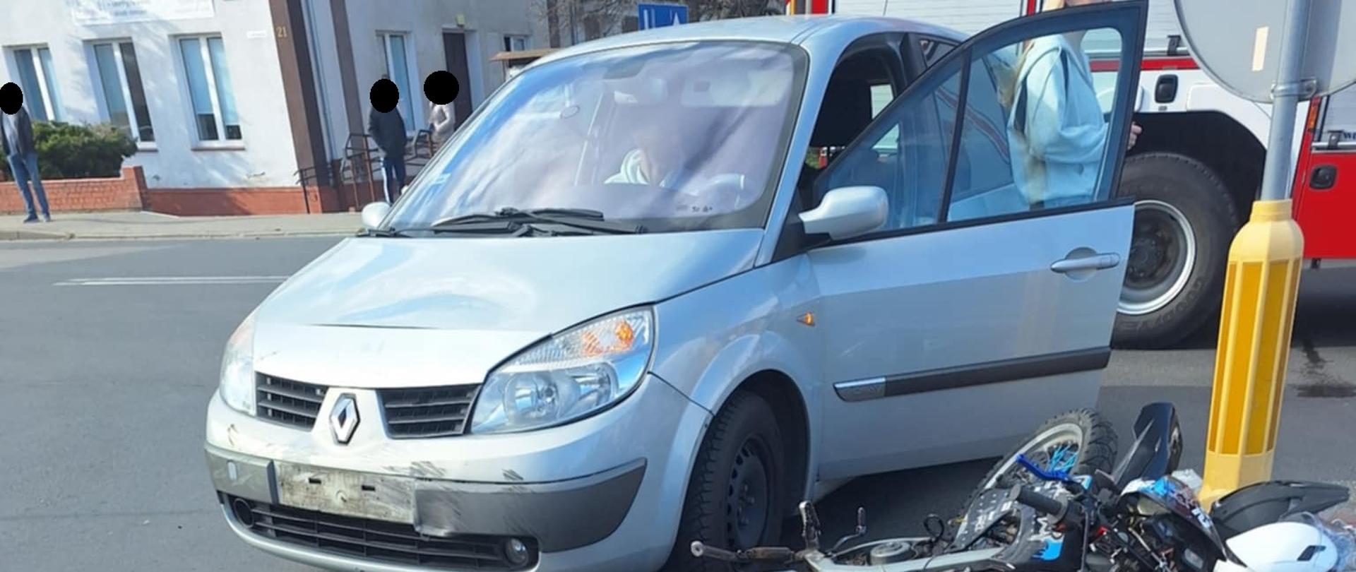 Samochód znajduje się na drodze, motocykl leży na wysepce